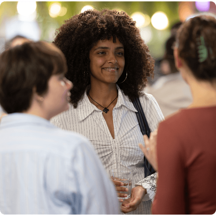 A group of three young women smiling at an event